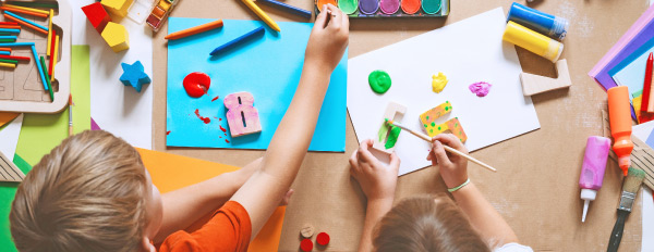 Bild f&uuml;r Projekt Kolibris: kleine Kinder basteln an einem Tisch