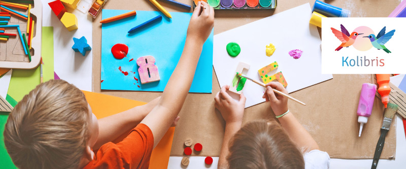Bild für Projekt Kolibris: kleine Kinder basteln an einem Tisch